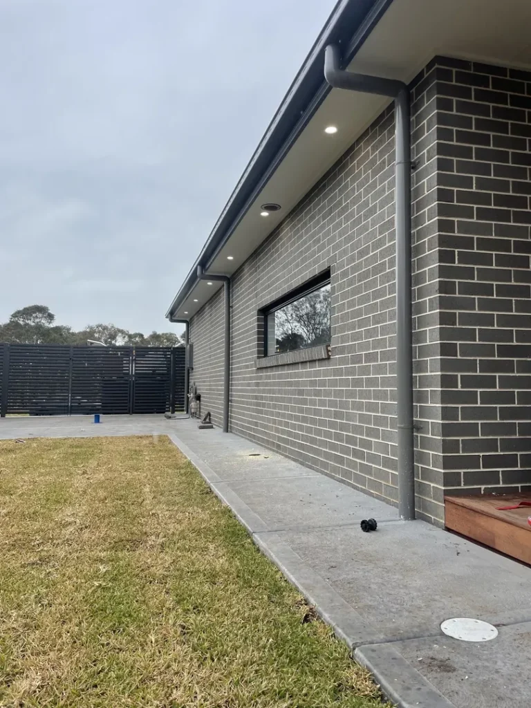 Modern brick house with patio and grass lawn.
