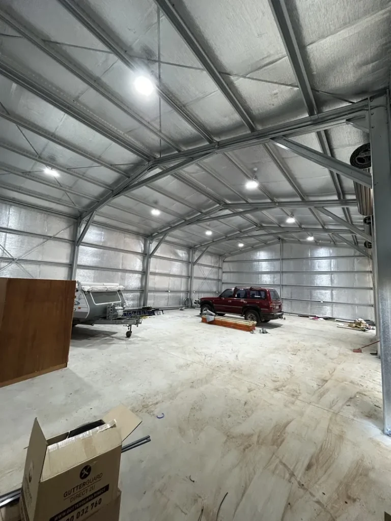 Metal workshop with truck and trailer inside