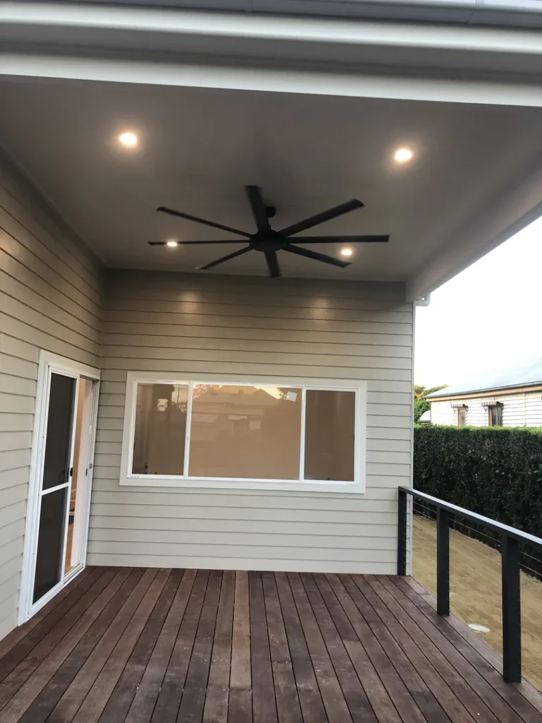 Outdoor patio with ceiling fan and wooden deck.